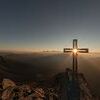 Ostern / Photo by eberhard grossgasteiger on Unsplash / CC0 License Kreuz auf einem Berggipfel im Gegenlicht